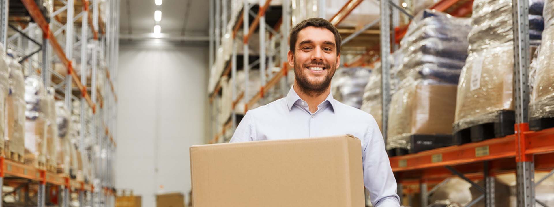 A man holding a box in a warehouse.